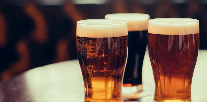Drei Biergläser mit unterschiedlichen Biersorten auf einem Tisch
