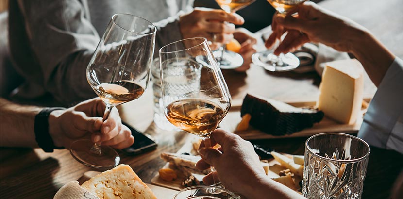 Leute stoßen mit Orange Wine an