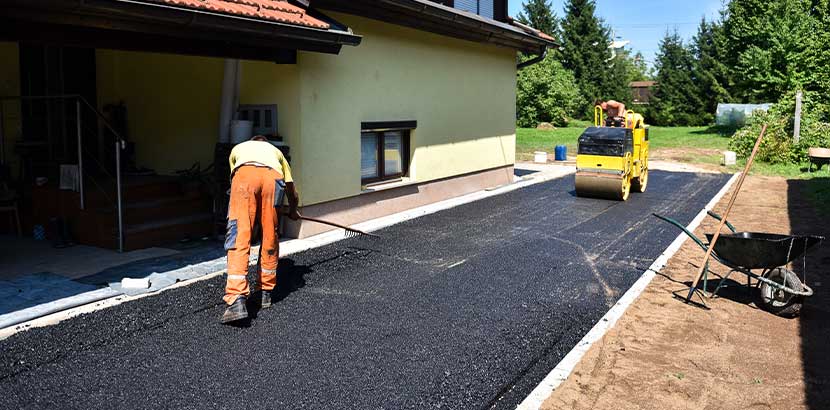 Arbeiter, die gerade eine Einfahrt asphaltieren.