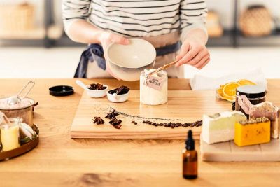 Frau, die in einer heimischen Küche Naturkosmetik zubereitet. Naturkosmetik Wien.