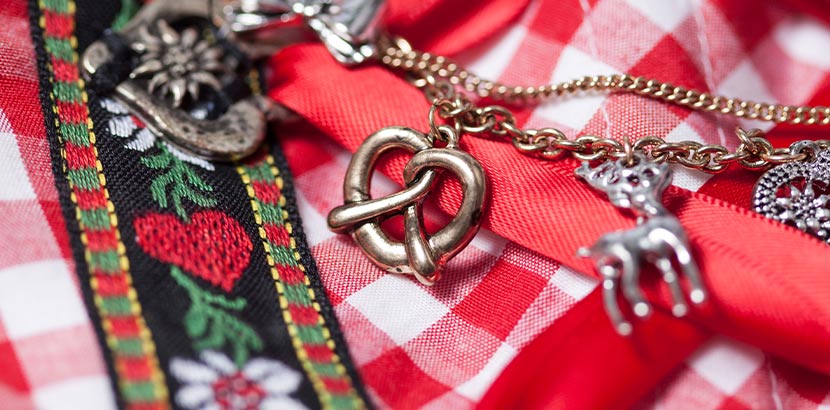 Zillertaler Trachtenwelt Österreich: Trachtenschmuck Kette mit Breze, Hirsch und Edelweiß auf einem karierten Hemd