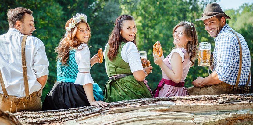 Trachtengeschäft Wien, Salzburg, Linz: eine Gruppe von Freunden in Dirndl, Lederhose, Trachtenhemd und Trachtenhut am Oktoberfest