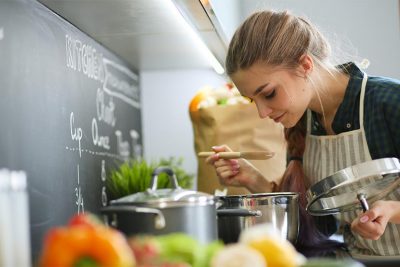 Frau kocht am Kachelofen