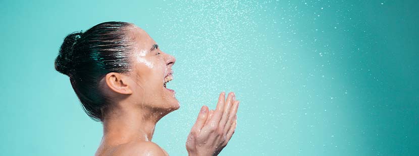 Regenwalddusche, Regendusche, Rainshower. Junge hübsche Brünette, die unter einer Regendusche steht und lacht.