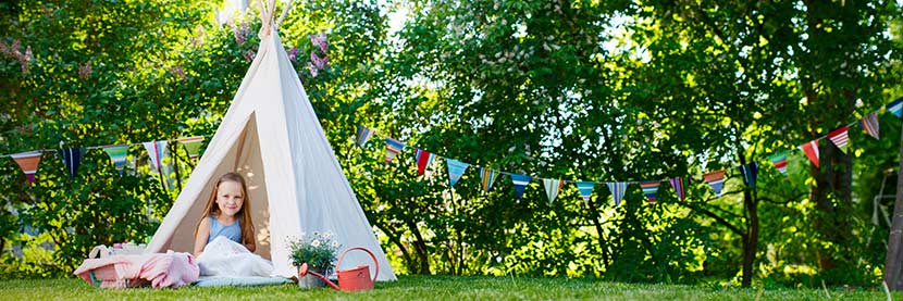 Kindermöbel Garten: Ein Mädchen sitzt in einem Zelt im Garten.