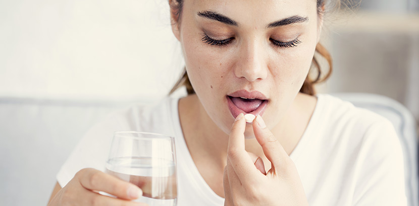 Eine Frau nimmt Antibiotika gegen ihre Blasenentzündung