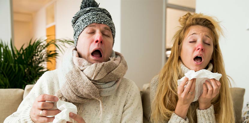 Ein Mann und eine Frau, die beide eine schlimme Erkältung haben und zum Hausarzt müssen. Hausarzt Wien.