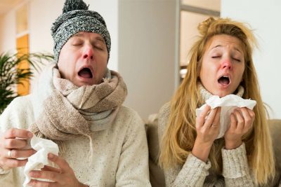 Ein Mann und eine Frau, die beide eine schlimme Erkältung haben und zum Hausarzt müssen. Hausarzt Wien.