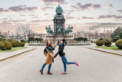 Zwei Freundinnen, die sich im herbstlichen Wien umarmen.