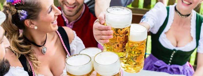 Gruppe von Frauen und Männern, die auf der Wiener Wiesn 2019 mit Biergläsern anstoßen.