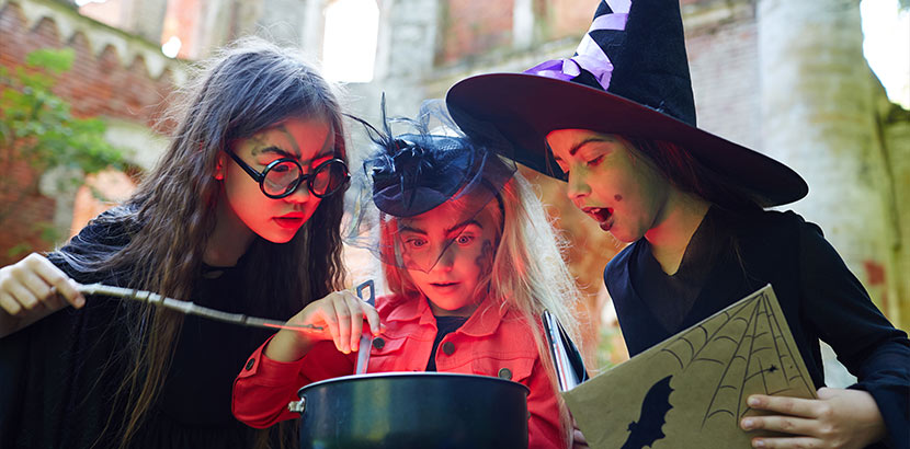 Drei neunjährige Mädchen in Hexen-Kostümen. Geschenke für 9-jährige Mädchen.