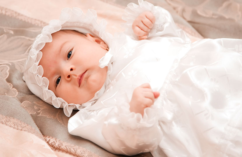 Ein Baby im weißen Taufkleid.