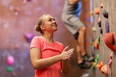 Junge Frau beim Indoor Klettern in der Kletterhalle Wien.