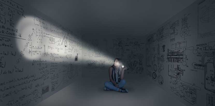 Junges Mädchen, das in einem dunklen Raum mit Rätseln an den Wänden sitzt. Indoor Aktivitäten Wien.