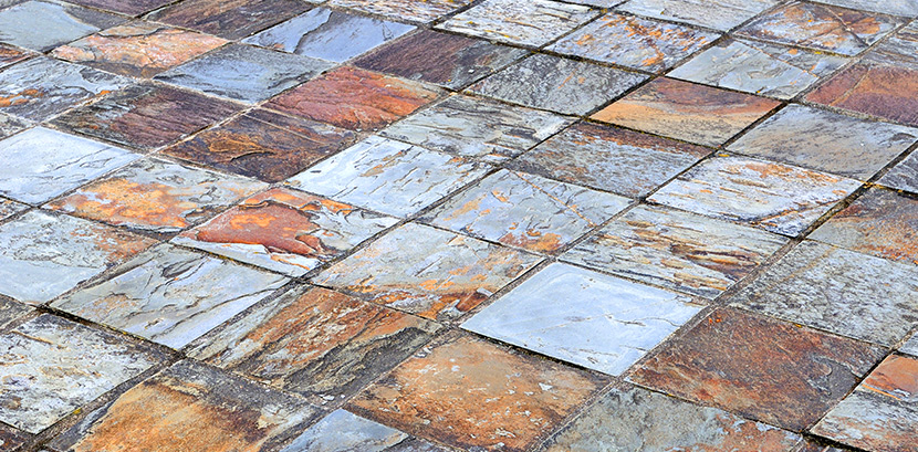 Ein Boden mit rauen Schiefer Fliesen in verschiedenen Farben von Hellgrau über Orange bis Rostbraun