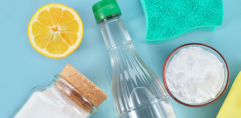 Hausmittel zum fugen Reinigen: Eine halbe Zitrone, eine Flasche Essig, ein Schwamm, ein Glas mit Zitronensäure und eine Schale mit Soda