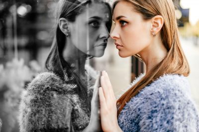 Junge Frau mit high functioning depression, die versucht, ihr Gesicht zu wahren.