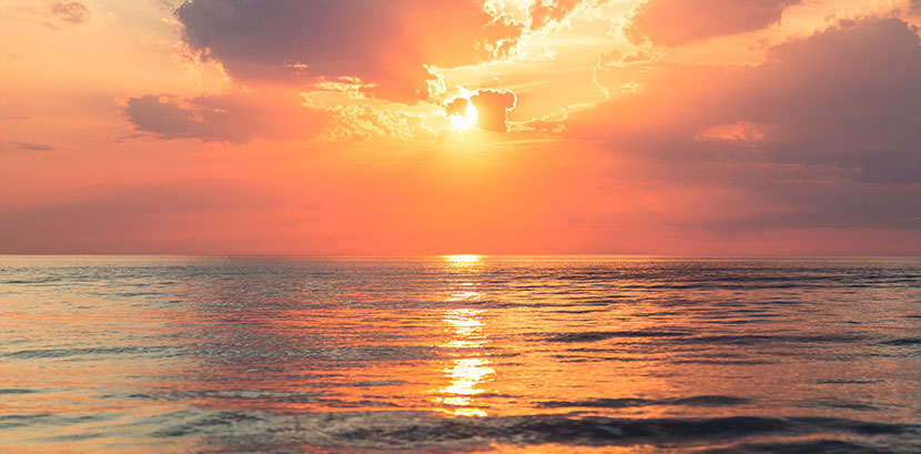 Sonnenallergie: Die Sonne geht über dem Meer unter.