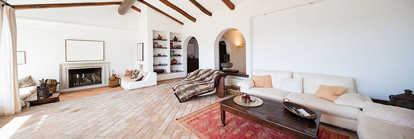 Teppich reinigen: Ein moderner, gemütlicher Raum mit einem roten Teppich und einem hellen Sofa.