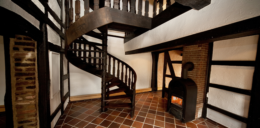 Wendeltreppe im Landhausstil aus dunklem Massivholz in einem Haus