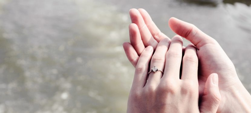 Damenhände mit einem Edelsteinring, der im Rahmen einer Diamantbestattung entstanden ist. Diamant aus Asche.