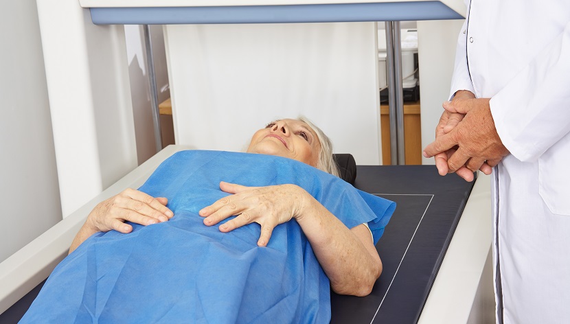 Seniorin liegt unter DXA zur Knochendichtemessung in der Radiologie