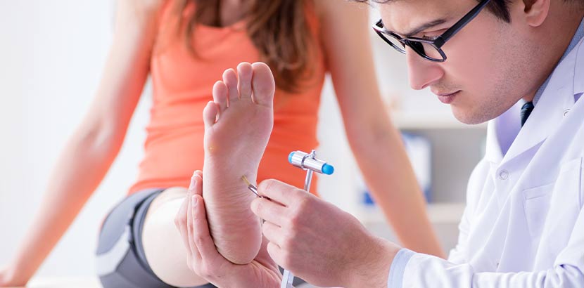 Junger Neurologe, der die Nerven einer jungen Patientin testet.