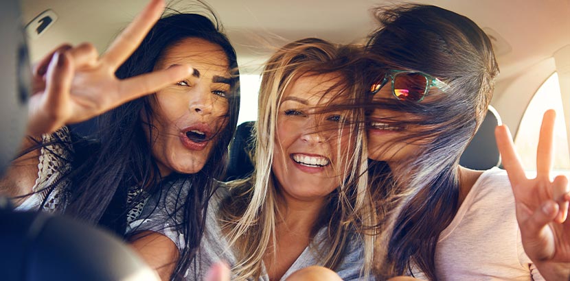 Festival-Packliste: Drei Frauen fahren im Auto zu einem Festival