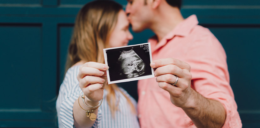 Mutter-Kind-Pass: Eltern zeigen das Ultraschallbild ihres Babys her