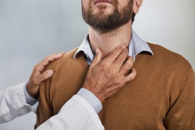 Kehlkopfkrebs - Arzt tastet Kehlkopf von Mann ab