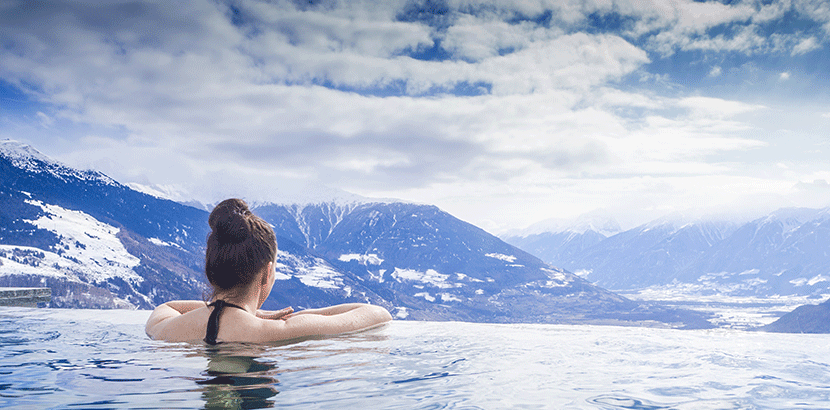 Urlaub in Österreich: Frau im Pool mit Blick auf Berge