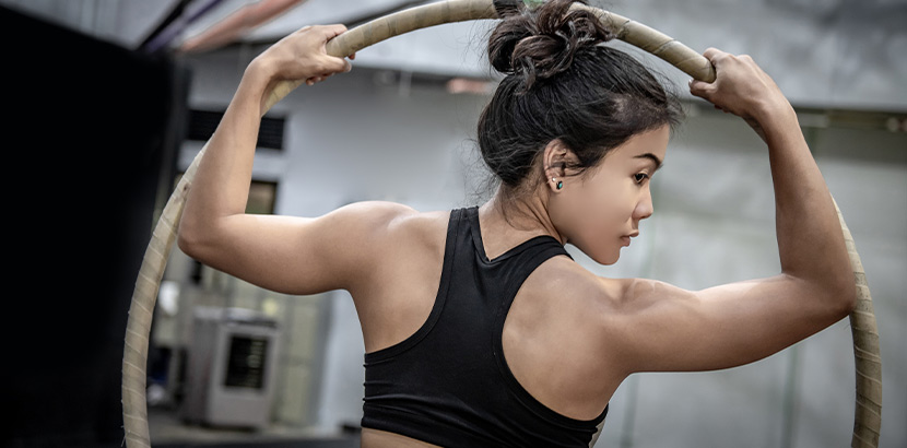 Aerial Hoop: eine Frau mit trainierten Muskeln mit einem Aerial Reifen