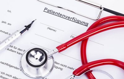 Ein Formular für eine Patientenverfügung, auf dem ein Kugelschreiber und ein Stethoskop liegen.