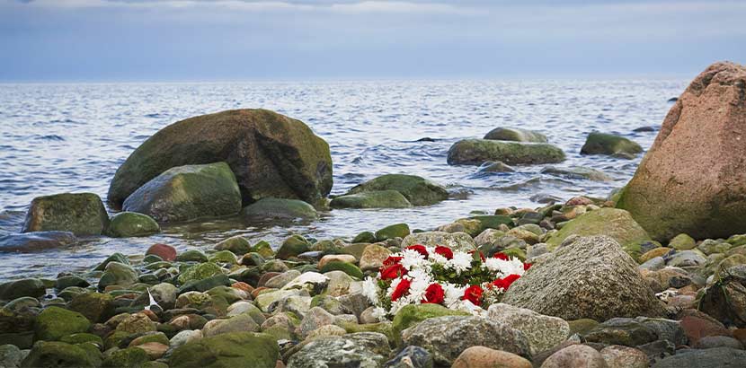 Blumenkranz, der nach einer Seebestattung an den Strand gespült wurde.