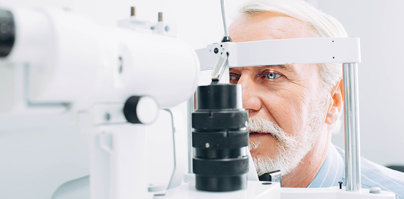 Ein Arzt verwendet eine Spaltlampe zum Zweck die richtigen Einstellungen für die Brille des Patienten zu finden.