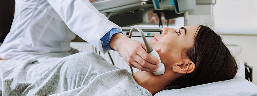 Junge brünette Patientin beim Schilddrüsen Ultraschall. Schilddrüsenspezialist Wien.