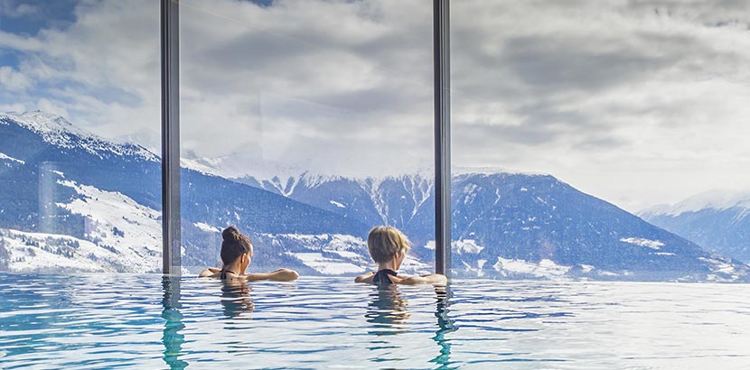 zwei Frauen in Pool mit Aussicht auf Berge in Salzburg