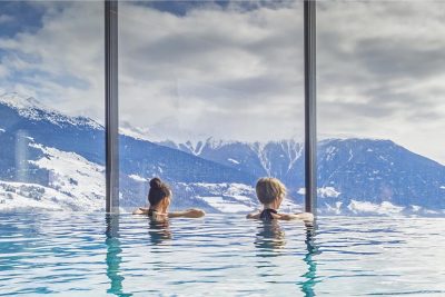 zwei Frauen in Pool mit Aussicht auf Berge in Salzburg