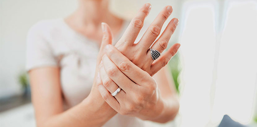 Junge Frau, die ihre schmerzende Hand in die Kamera hält und nach einem Handchirurgen sucht.