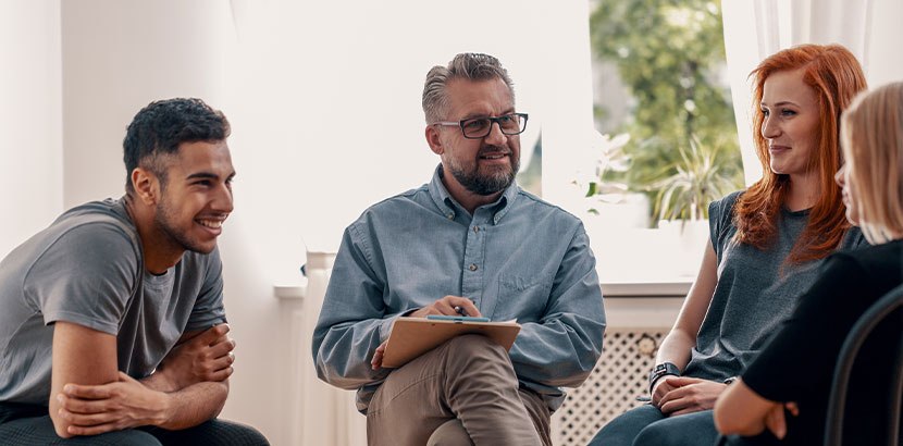 Eine Gruppe Jugendlicher die sich in der Gruppentherapie öffnen.