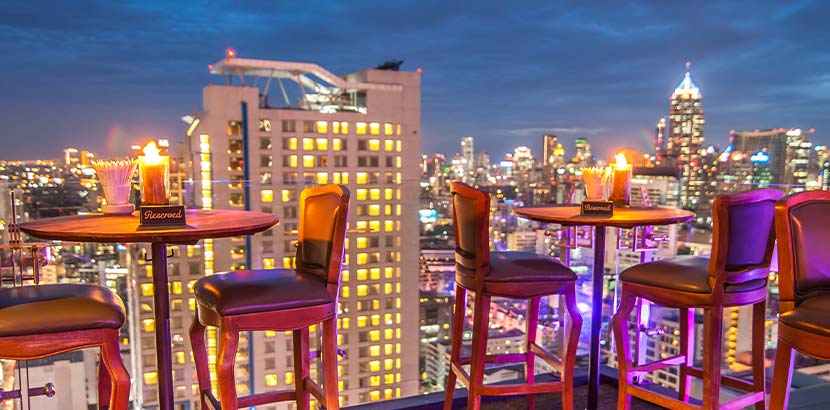 Eine Dachterrasse über den Dächern mit Ausblick auf die Straße. Rooftop Bar Vienna