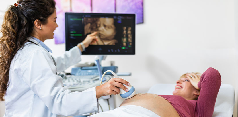 Frauenärztin, die bei einer schwangeren Patientin eine Ultraschalluntersuchung macht. Frauenarzt Linz.