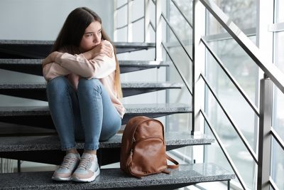 Trauriges Mädchen in der Schule. Mobbing in der Schule.