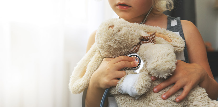 Eine Tochter mit ihrer Mutter und einem Stofftier beim Kinderarzt Termin.