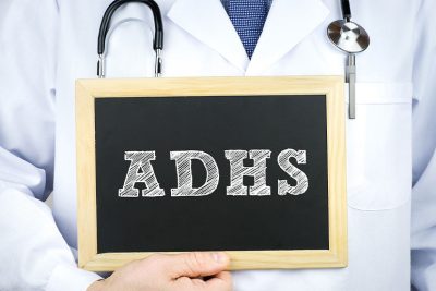 ADHS-Experte und Facharzt hält eine Tafel hoch.