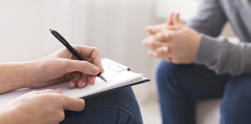 Psychologe gibt Patient Informationen über Psychosomatik und medizinische Faktoren bei Burn-Out.