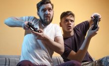 Zwei Gamer beim Spielen vor dem Fernseher.