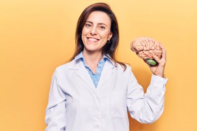 Fachärztin für Neurologie mit Hirnmodell.