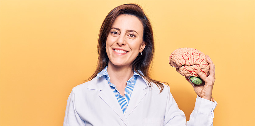 Fachärztin für Neurologie mit Hirnmodell.