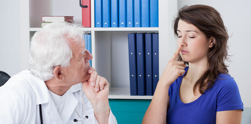 Arzt verwendet Finger-Nase-Versuch um die Koordination einer Patientin zu testen.